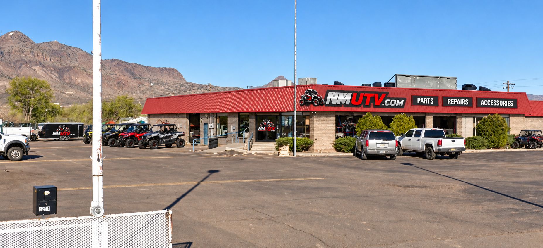NM UTV shop storefront at 1261 Frontage Rd NW in Socorro, New Mexico, with side-by-sides parked out front